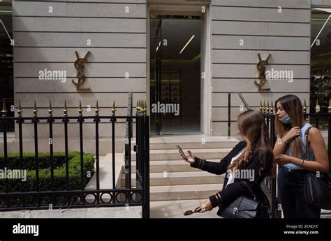 Les acheteurs prennent un selfie devant le magasin Christian 